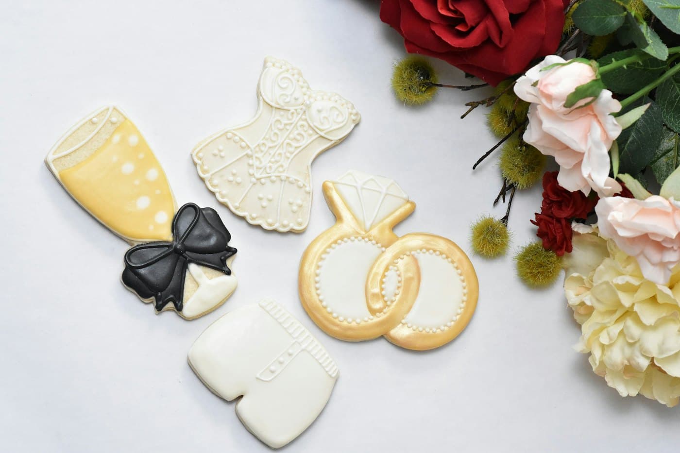 Iced wedding cookies beside fresh flowers